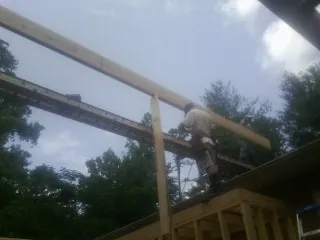 Carpenter setting a ridge beam over a new addition frame — Ice Dam Removal by Roofing Brothers in Elkton